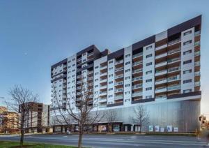 a large apartment building with a street in front of it at Entire apartment with lake view in Tuggeranong