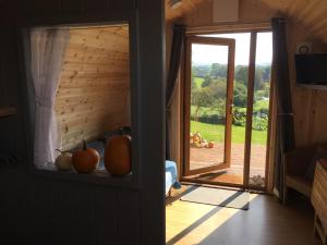 Garden Cottage Glamping Pod في Boncath: غرفة بها باب ونافذة بها فاكهة على رف