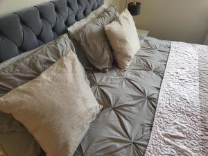 a bed with three pillows on it at & Cosy Apartment in the heart of Stokes Croft in Bristol