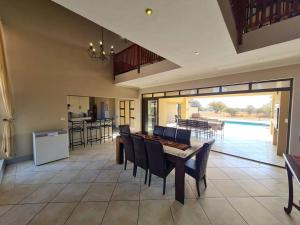 a kitchen and dining room with a table and chairs at Moshate Lodge Zebula 4 Bedroom Holiday home in Mabula