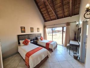 - une chambre avec 2 lits dans une chambre avec une fenêtre dans l'établissement Moshate Lodge Zebula 4 Bedroom Holiday home, à Mabula 39 autres photos