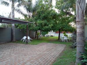 a patio with tables and chairs and trees at Yatale II in Chascomús