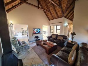 a living room with a leather couch and a table at Moshate Lodge Zebula 4 Bedroom Holiday home in Mabula