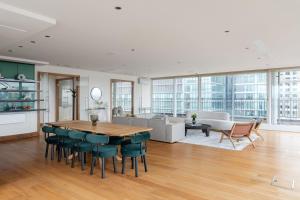 倫敦的住宿－The Canary Wharf Secret - Glamorous 3BDR Flat with Terrace and Parking，厨房以及带桌椅的起居室。
