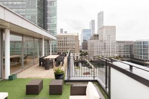 uma varanda com vista para o horizonte da cidade em The Canary Wharf Secret - Glamorous 3BDR Flat with Terrace and Parking em Londres