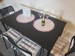 a black table with two plates and a bottle of champagne at & Cosy Apartment in the heart of Stokes Croft in Bristol