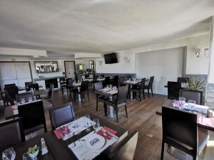 un comedor con mesas y sillas en un restaurante en Hôtel Inn Design Resto Novo Langres, en Langres