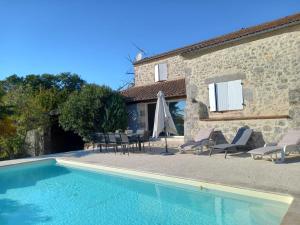 a house with a swimming pool next to a building at Gite de Micouleau in Nérac