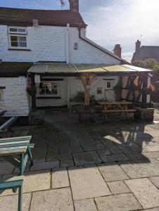 a patio with a picnic table and an umbrella at George Inn st briavels in Lydney