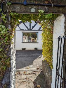 una entrada a un edificio con una puerta cubierta de hiedra en George Inn st briavels en Lydney