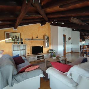 sala de estar con 2 sofás y TV en Casa Zanier Cigolotti Aviano en San Martino