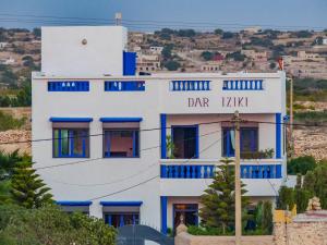 ein blau-weißes Gebäude mit einem Schild darauf in der Unterkunft Dar Iziki in Sidi Kaouki