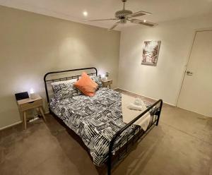 Dormitorio con cama con almohada naranja en Spacious 4BR getaway with panoramic water & mountain view, en Green Point