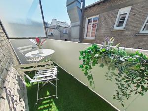 un pequeño balcón con una mesa y algunas plantas en Logement Place d'Erlon hypercentre avec balcon, en Reims