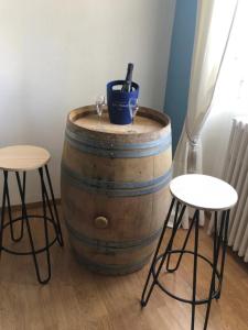 a barrel with two wine glasses and two stools at Logement Place d'Erlon hypercentre avec balcon in Reims