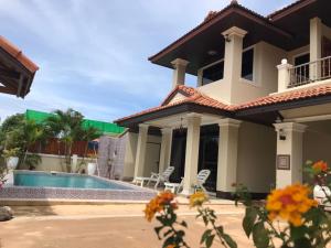 a villa with a swimming pool and a house at Orchid Pool -Villa 3 bedrooms in Ko Lanta