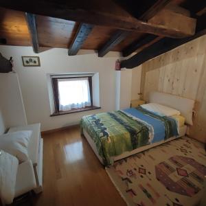 um quarto com uma cama e uma cadeira num quarto em Casa Zanier Cigolotti Aviano em San Martino