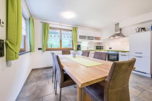 eine Küche und ein Esszimmer mit einem Holztisch und Stühlen in der Unterkunft Alpenappart App Weiße Zinne in Steinhaus