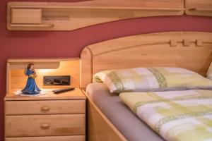 ein Schlafzimmer mit einem Bett und einer Puppe auf einem Nachttisch in der Unterkunft Alpenappart App Weiße Zinne in Steinhaus