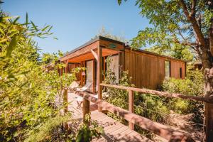 a wooden cabin in the woods with a wooden walkway at Rives d'Arc in Vallon-Pont-dʼArc