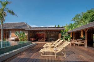 una terraza de madera con sillas y una piscina en Secret River Villa - Luxury Villa 5 Bedrooms - Kerobokan - Canggu en Kerobokan