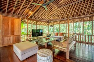 Secret River Villa - Luxury Villa 5 Bedrooms - Kerobokan - Canggu في كيروبوكان: غرفة معيشة مع أريكة وتلفزيون