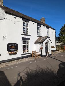 a white building with a bench in front of it at George Inn st briavels in Lydney