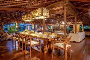 a dining room with a large wooden table and chairs at Secret River Villa - Luxury Villa 5 Bedrooms - Kerobokan - Canggu in Kerobokan