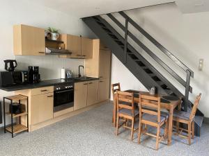 a kitchen with a table and chairs and a staircase at Ferienwohnung Strackholt in Großefehn 