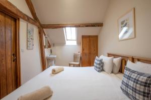 una camera da letto con un grande letto bianco e una finestra di The Stables a Bromyard