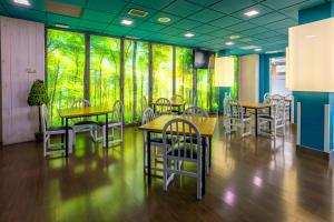 un comedor con mesas y sillas y una pared de ventanas en Hotel Navarro, en Ciudad Real