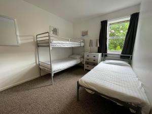 1 dormitorio con 2 literas y ventana en Bath YMCA Hostel, en Bath