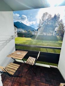 a balcony with a picnic table and a view of a field at Wellness-Apartment Seefeld and Chill SPA im Zentrum mit Pool, Sauna und Netflix for free in Seefeld in Tirol
