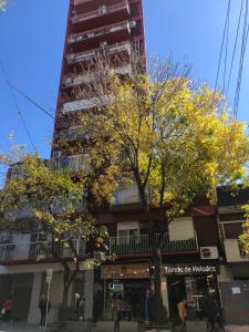 un edificio alto con un árbol delante de él en Hermoso 2 ambientes en Palermo Hollywood en Buenos Aires