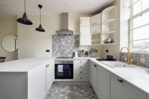 ロンドンにあるThe West End Penthouse - 4BDR with Viewsの白いキャビネットとシンク付きのキッチン