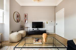 a living room with a glass coffee table and a tv at The West End Penthouse - 4BDR with Views in London