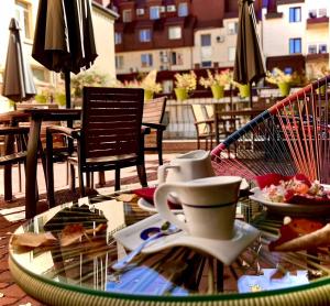 a glass table with plates of food on a patio at Hotel Adria in Sofia