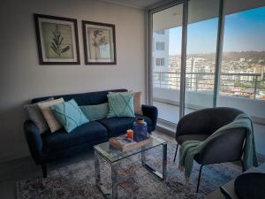 sala de estar con sofá, 2 sillas y mesa en Exclusivo Departamento a Pasos de la Playa en Viña, en Viña del Mar