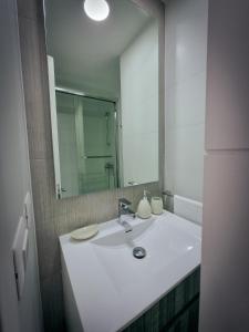a bathroom with a white sink and a mirror at Exclusivo Departamento a Pasos de la Playa en Viña in Viña del Mar