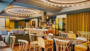 ein Restaurant mit Tischen und Stühlen und eine Bar in der Unterkunft StayParis in Issy-les-Moulineaux