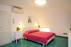 アマルフィにあるDomus Florio Sabbiaのベッドルーム(赤いベッド1台、白いドレッサー付)
