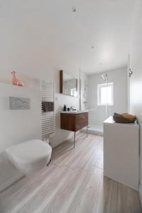 uma casa de banho com um WC, um lavatório e uma secretária. em Résidence Epinat - Appartements centre & parking em Vichy