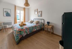 ein Schlafzimmer mit einem Bett, auf dem ein Teddybär liegt in der Unterkunft Résidence Epinat - Appartements centre & parking in Vichy