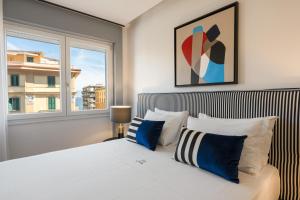 ナポリにあるLe Mummarelle Napoliのベッドルーム1室(青と白の枕が備わるベッド1台付)