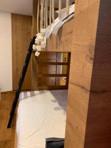 Cama elevada en habitación con paredes de madera en Ciasa Ciaccio, en San Vigilio Di Marebbe