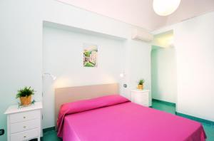 アマルフィにあるDomus Florio Coralloのベッドルーム(ピンクベッド1台、白いキャビネット付)