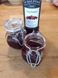 a bottle of jam sitting on a wooden table at Nyhagens trädgård och B&B 