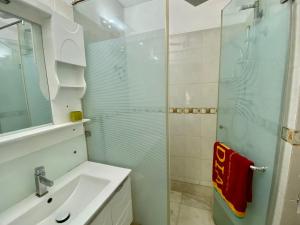 a bathroom with a sink and a glass shower at Ardee City Heart Of Gurugram security Comfort in Gurgaon