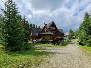 une grande maison en bois installée au-dessus d'un champ dans l'établissement GliczarowSki u Zbója, à Zakopane