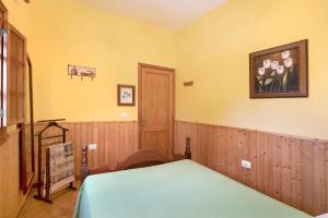 a bedroom with a bed and a painting on the wall at Finca Imoses Bailon in Santa Cruz de Tenerife